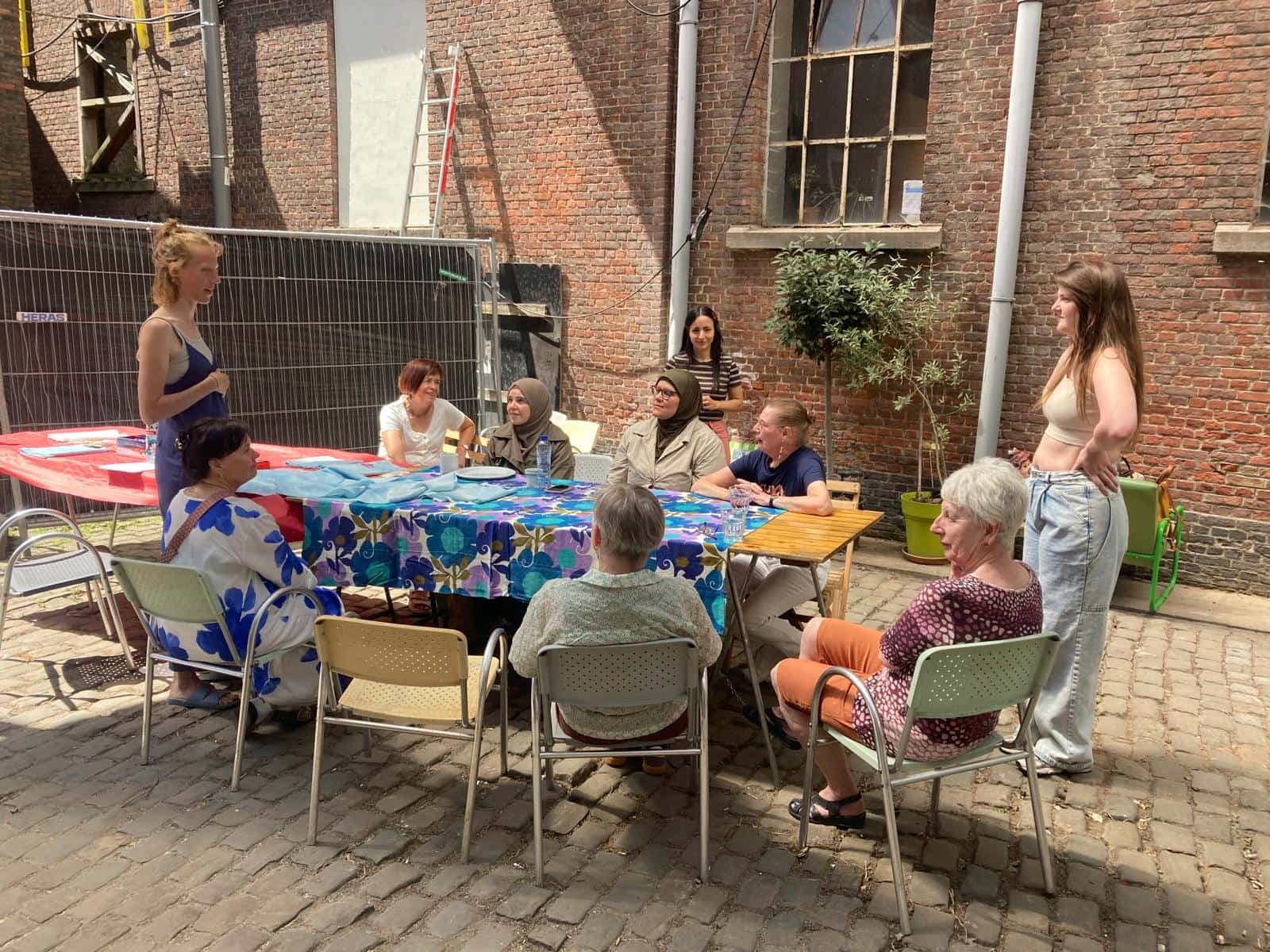 Bezoekers aan tafel op het binnenplein van maakleerplek