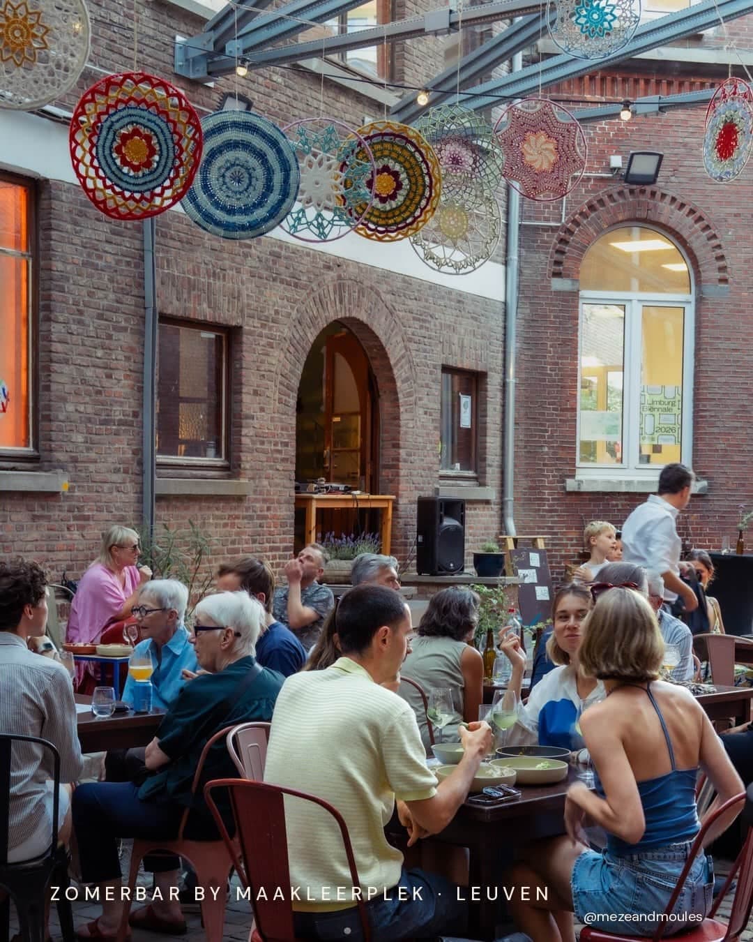 Bezoekers aan tafel op het binnenplein tijdens de zomerbar