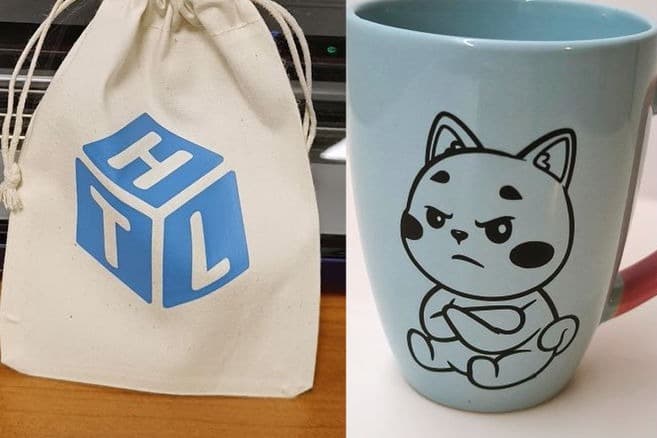 Een stoffen zakje met het High Tech Lab-logo en een mok met een kattenfiguur in vinyl